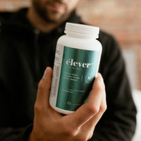 A mans hands holding a bottle of Elever Plus MensBalance. Boost. Digestion. Energy. Renew. Refresh. 60 capsules.  NUsisters.