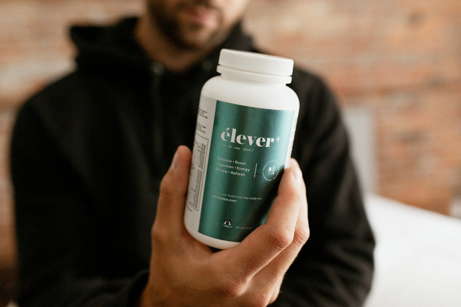 A mans hands holding a bottle of Elever Plus MensBalance. Boost. Digestion. Energy. Renew. Refresh. 60 capsules.  NUsisters.
