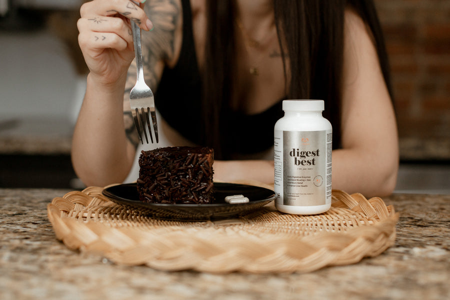 A large white bottle of Digest Best Digestive enzyme. Daily Digestive Enzyme. Decrease bloating and gas. Heartburn relief. Enhance liver health. NUsisters. 60 Capsules. Woman eating cake in the background. 60 capsules.