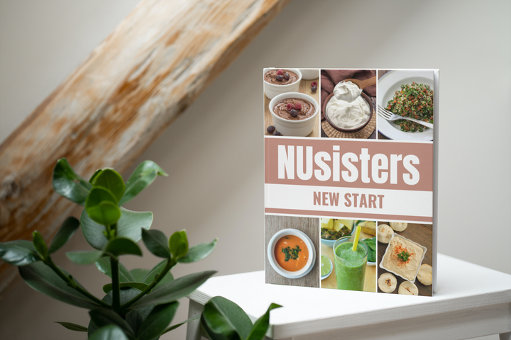 Image of the NUsisters New Start Cookbook. An 8 week guide for a health overhaul. The book is sitting on a table with wood and a plant in the background.